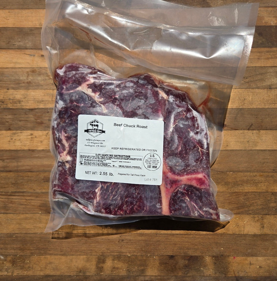 Frozen Beef Chuck Roast in a clear vacuum-sealed bag with a white product label, placed on a wooden surface