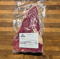vacuum-sealed tri-trip beef roast displayed on a wooden baord
